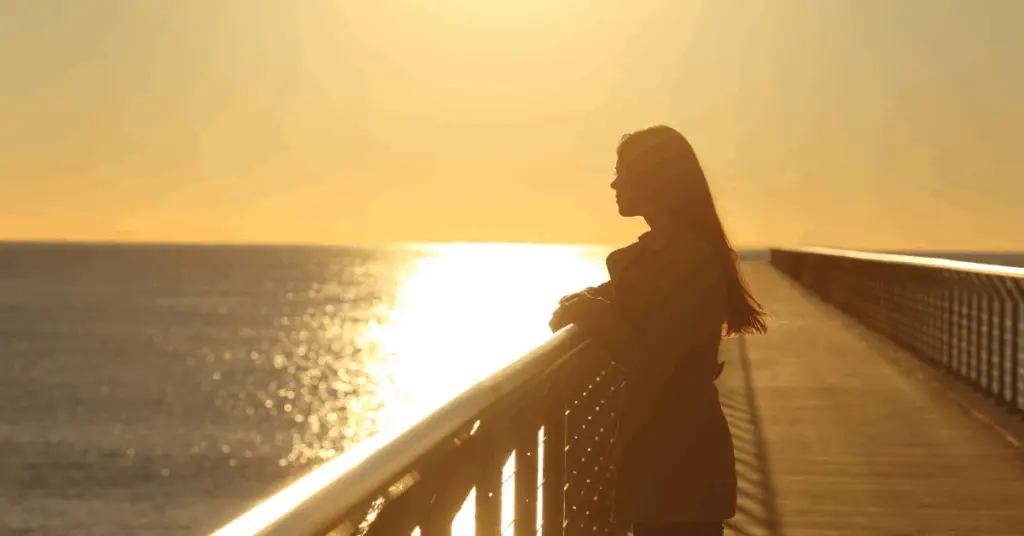 A midlife woman reflecting quietly at home, surrounded by gentle light, symbolizing the strength in vulnerability.